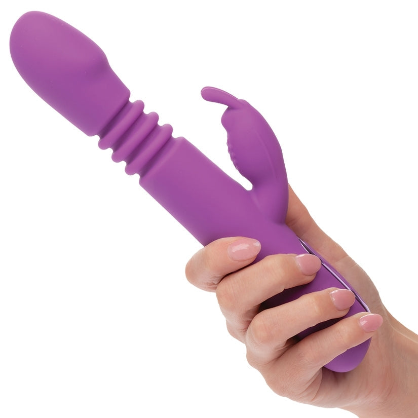 Purple silicone tool held by a hand on a white background