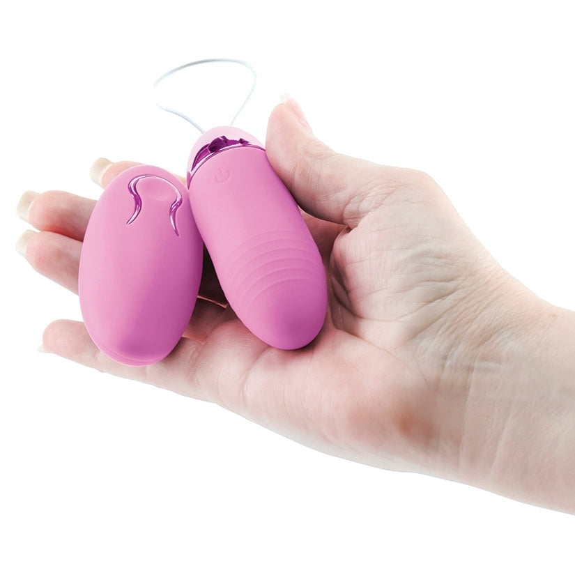 Pink and purple toy held in a hand against a white background