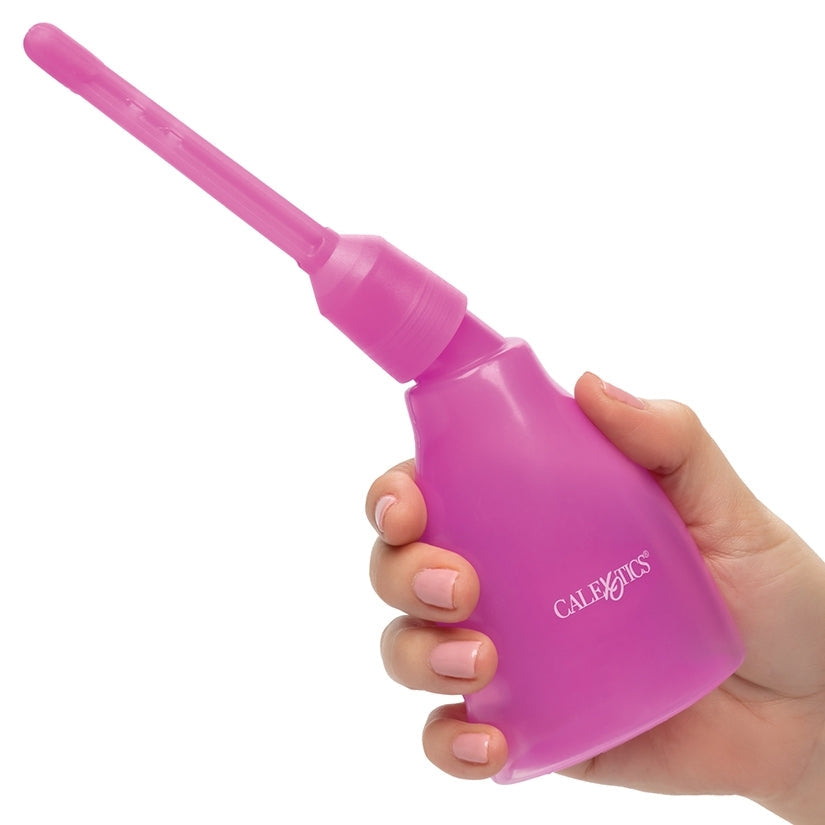 Pink nasal aspirator held in a hand against a white background